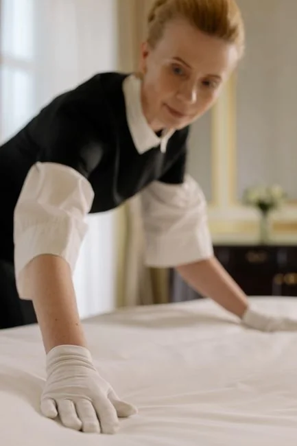 A detailed view of a hand cleaning a stovetop using a spray bottle and cloth.
